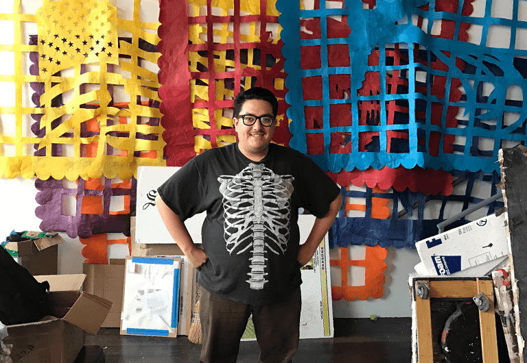 Juhl’s first resident artist, Justin Favela, standing in front of his work.