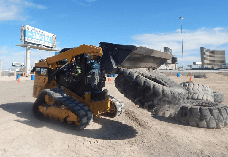 Excavator lifting a 2,000 pound tire.