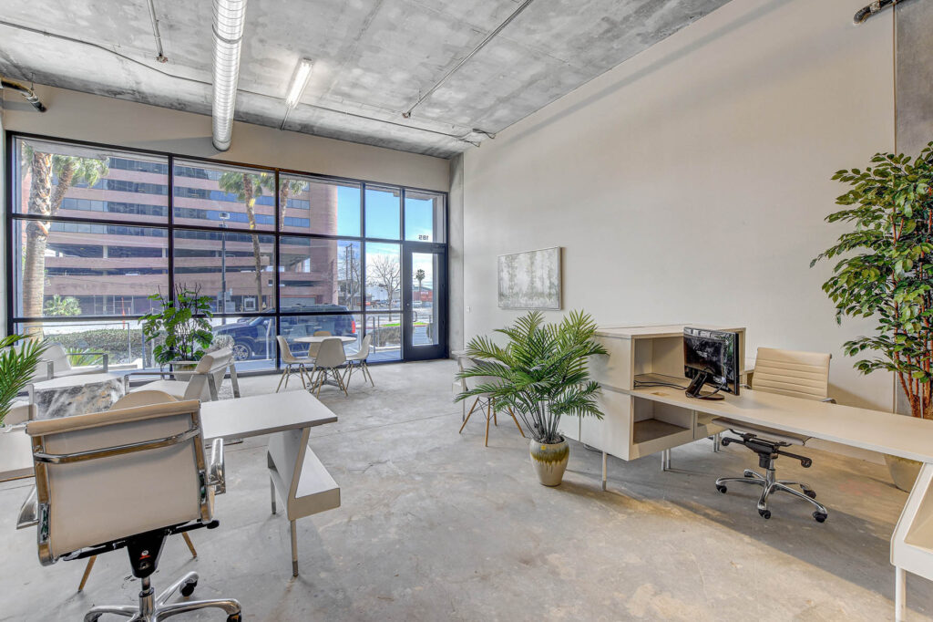 desks in open industrial office with large windows