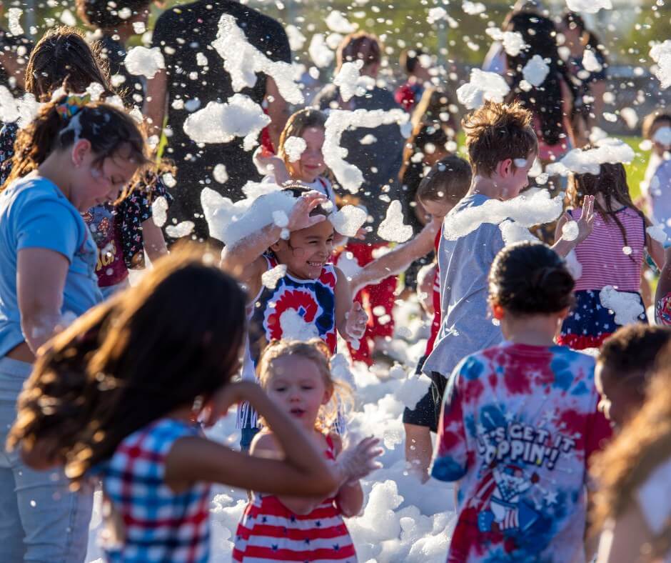 families celebrate amongst bubbles in holiday parade