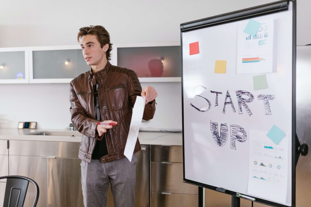 man stands in front of white board during meeting presentation