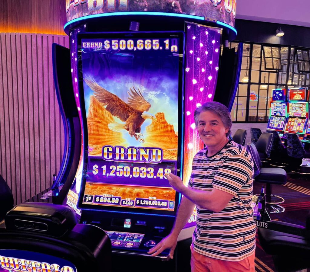 person stands in front of slot machine in vegas to show winning screen